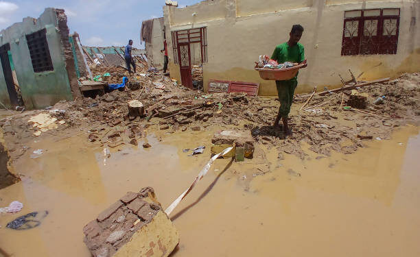 People save things from a destroyed house following heavy rains in Abu Hamad, in Sudan's River Nile state, some 400 kilometres (nearly 250 miles) north of Khartoum, on August 9, 2024. Heavy rains have triggered building collapses that have killed 17 people in northern Sudan, as the country reels from almost 16 months of fighting between rival security forces, a medic told AFP. (Photo by AFP) (Photo by -/AFP via Getty Images)